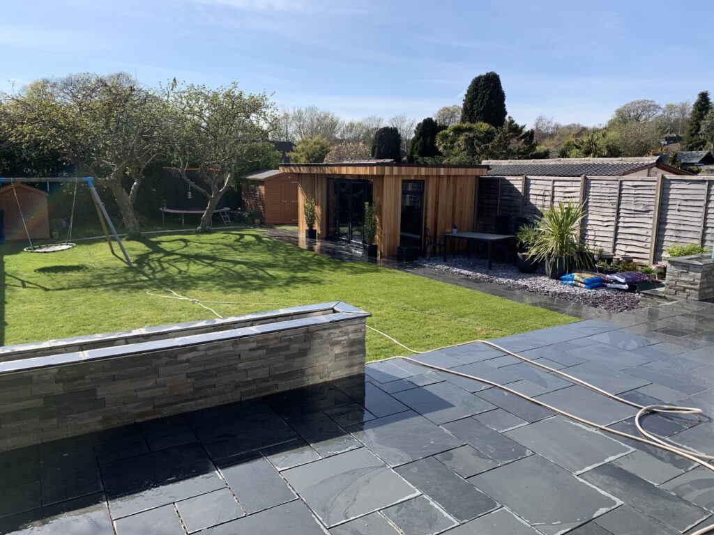 Slate patio and steps with sandstone clad walls, lighting and home cinema room in Worthing