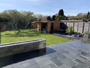 Slate patio and steps with sandstone clad walls, lighting and home cinema room in Worthing